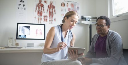 Doctor talking patient through their data records