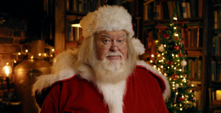 Father Christmas stood in front of a Christmas tree