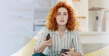 Woman watching TV with her mobile phone