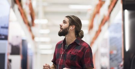 Customer looking up in a shopping centre while listening to a podcast