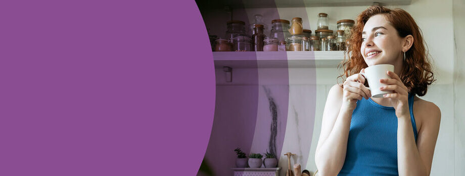 Woman sat in kitchen with a cup of tea