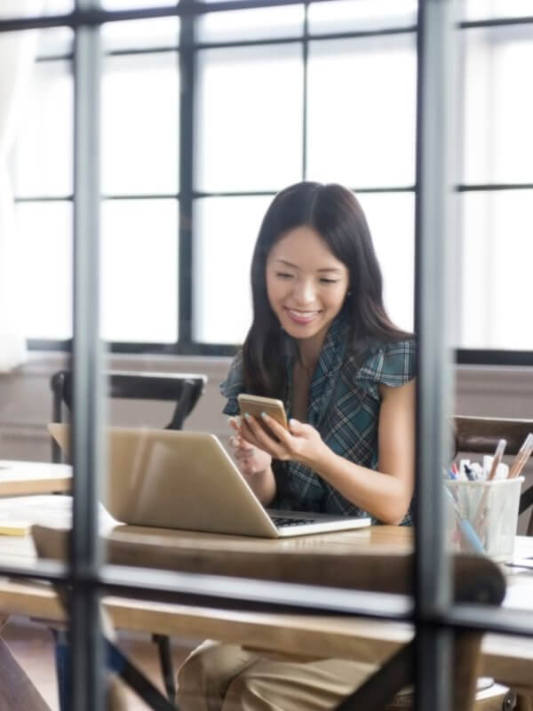 Young woman smiling at her mobile phone