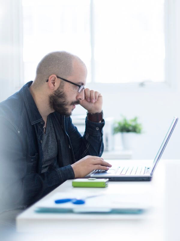 Man looking at data on his laptop at the office