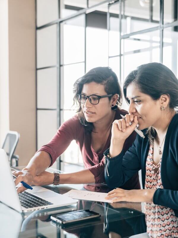 Group of colleagues gathered around a computer looking at fraud data